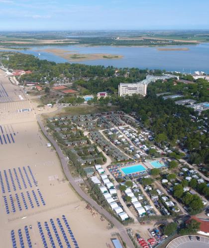 Beach with umbrellas, camping, and pool by the sea.