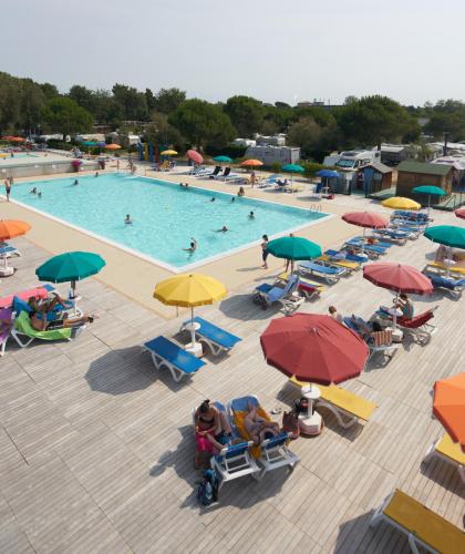 Outdoor pool with colorful umbrellas and loungers.