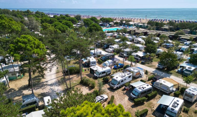 Campingplads med campingvogne nær havet og udstyret strand.